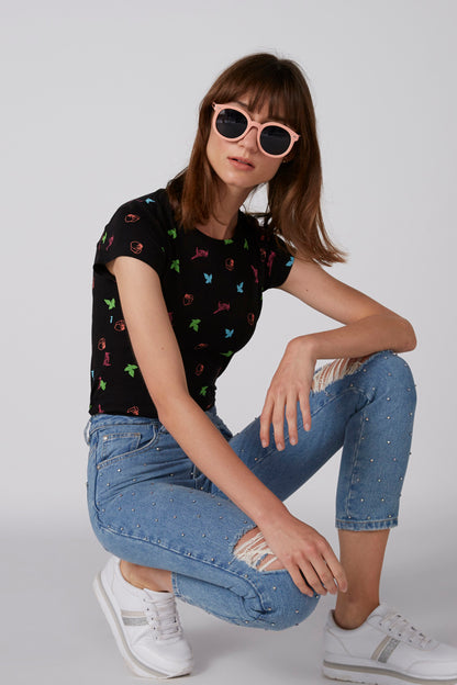 Black graphic T-shirt with colorful icons, short sleeves, worn with jeans