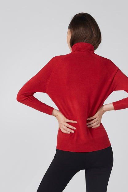 Red turtleneck long-sleeve top, back view with hands on hips