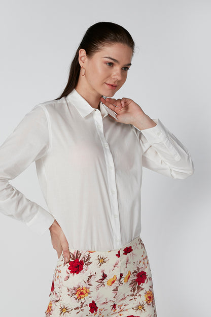 White button-up shirt with collar and red floral print pants, close-up