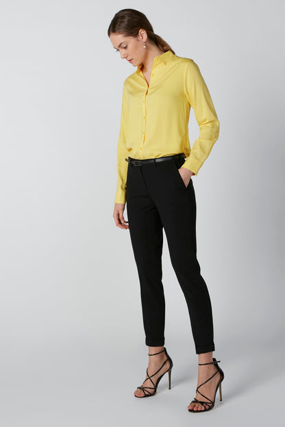 Yellow button-up blouse with long sleeves and collar, button front, tucked in black pants