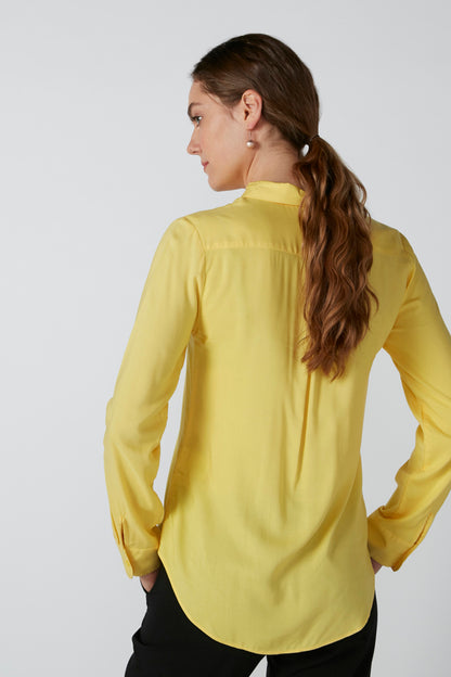 Yellow button-up blouse viewed from back, long sleeves and collar