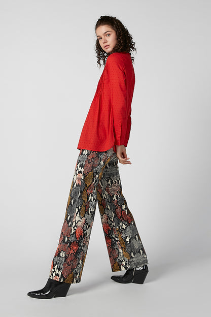 Red long-sleeve blouse with button front and pintuck texture, side profile