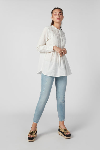 White long-sleeve blouse with vertical texture and curved hemline