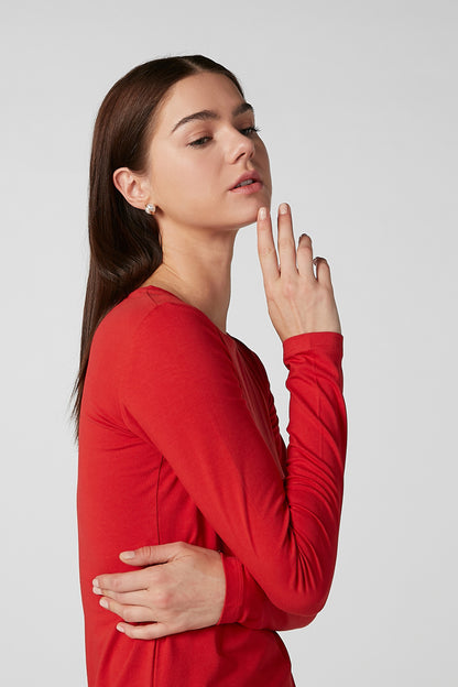 Red long-sleeve top, side view, with black floral tiered maxi skirt