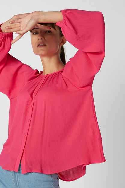 Fuchsia pink blouse with puffed sleeves, gathered neckline, and button placket