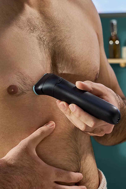 Black handheld Philips grooming trimmer with blue-tipped guard, used on chest