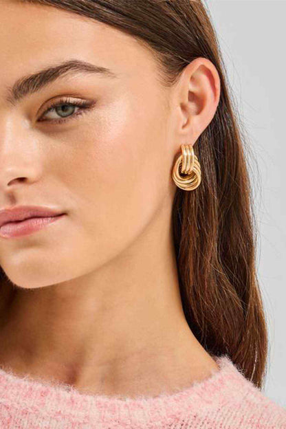 Gold multi-loop hoop earrings, small twisted drop design on model