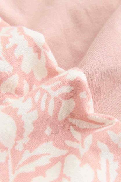 Close-up of pink patterned lounge pants fabric with light floral print