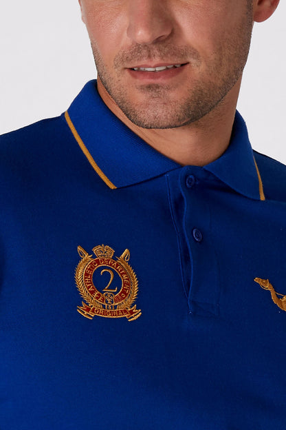 Blue polo shirt with button placket and embroidered crest on chest