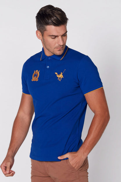 Blue polo shirt with embroidered crest and winged emblem on chest