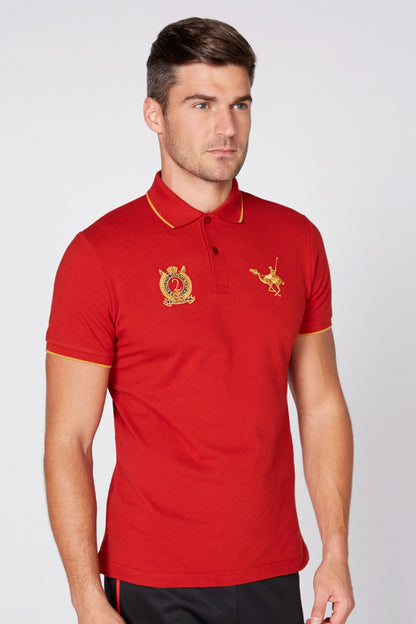 Red polo shirt with gold-trim collar, crest patch and horse rider emblem