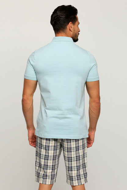 Light blue polo shirt with collar and short sleeves, worn with plaid shorts (back view)