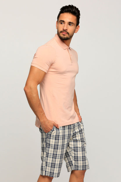 Men's pink polo shirt with plaid shorts, side view, button collar and cuffs