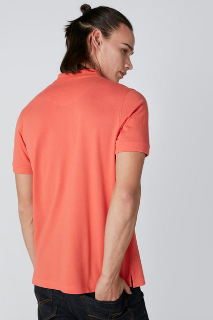 Orange polo shirt, back view, short sleeves and curved hem