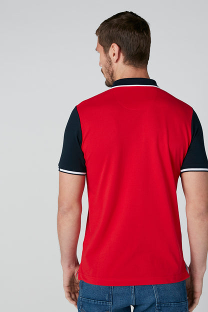 Back view of red polo shirt with dark navy sleeve trim