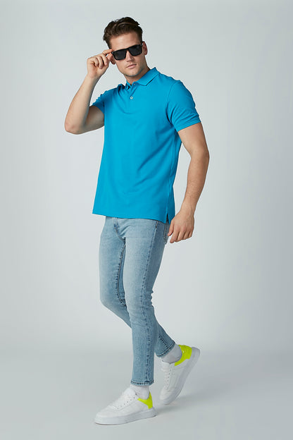 Blue polo shirt with short sleeves and buttoned collar, worn with jeans