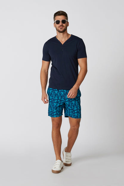 Men's navy short-sleeve henley shirt with blue tropical print shorts, full length