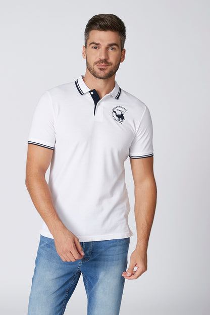 White polo shirt with navy trim collar and sleeve cuffs, small chest logo