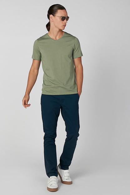 Green short-sleeve T-shirt with V-neck, model wearing dark blue pants
