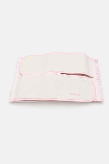 Cream waist support belt with pink border and hook-and-loop center panel, folded
