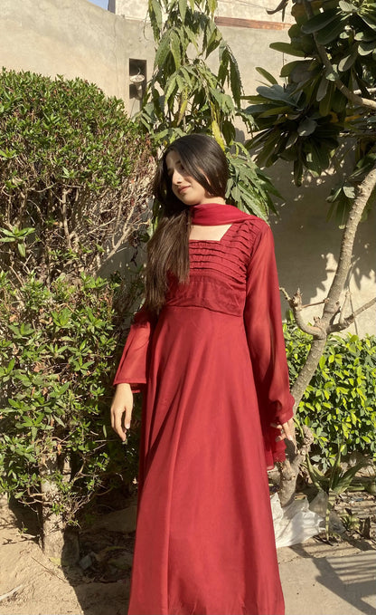 Red maxi dress with ruffle accents on the shoulders and long sleeves, side view outdoors
