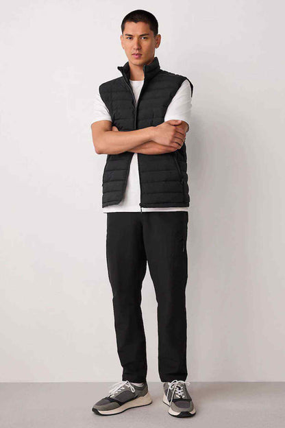 Black quilted puffer gilet and black straight-leg trousers, sleeveless vest