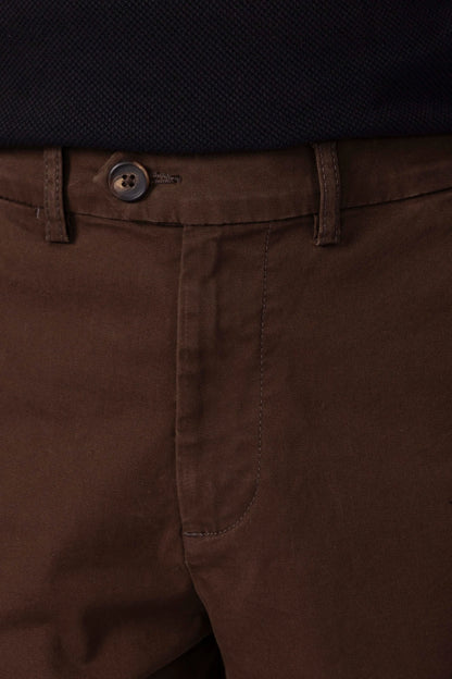 Men's brown chinos, close-up of button waist and front seams