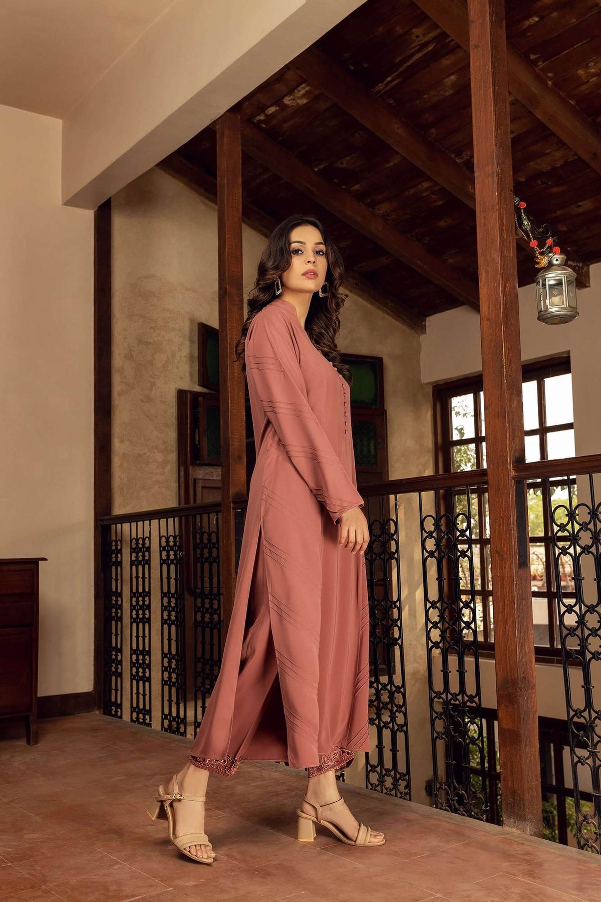Pink velour long dress with long sleeves, button front, and lace details at hem