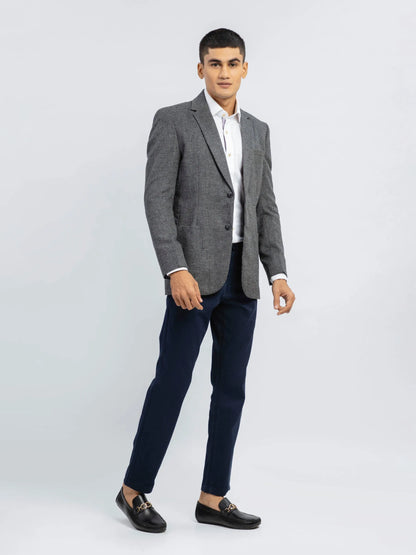 Grey textured single-breasted blazer with notch lapel over dark trousers