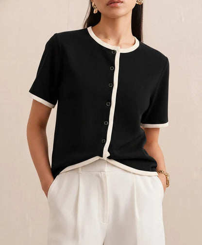 Black fitted button-front short-sleeve top with white contrast trim and cuffs