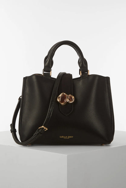 Black handbag with top handles, front clover hardware, and zip pocket
