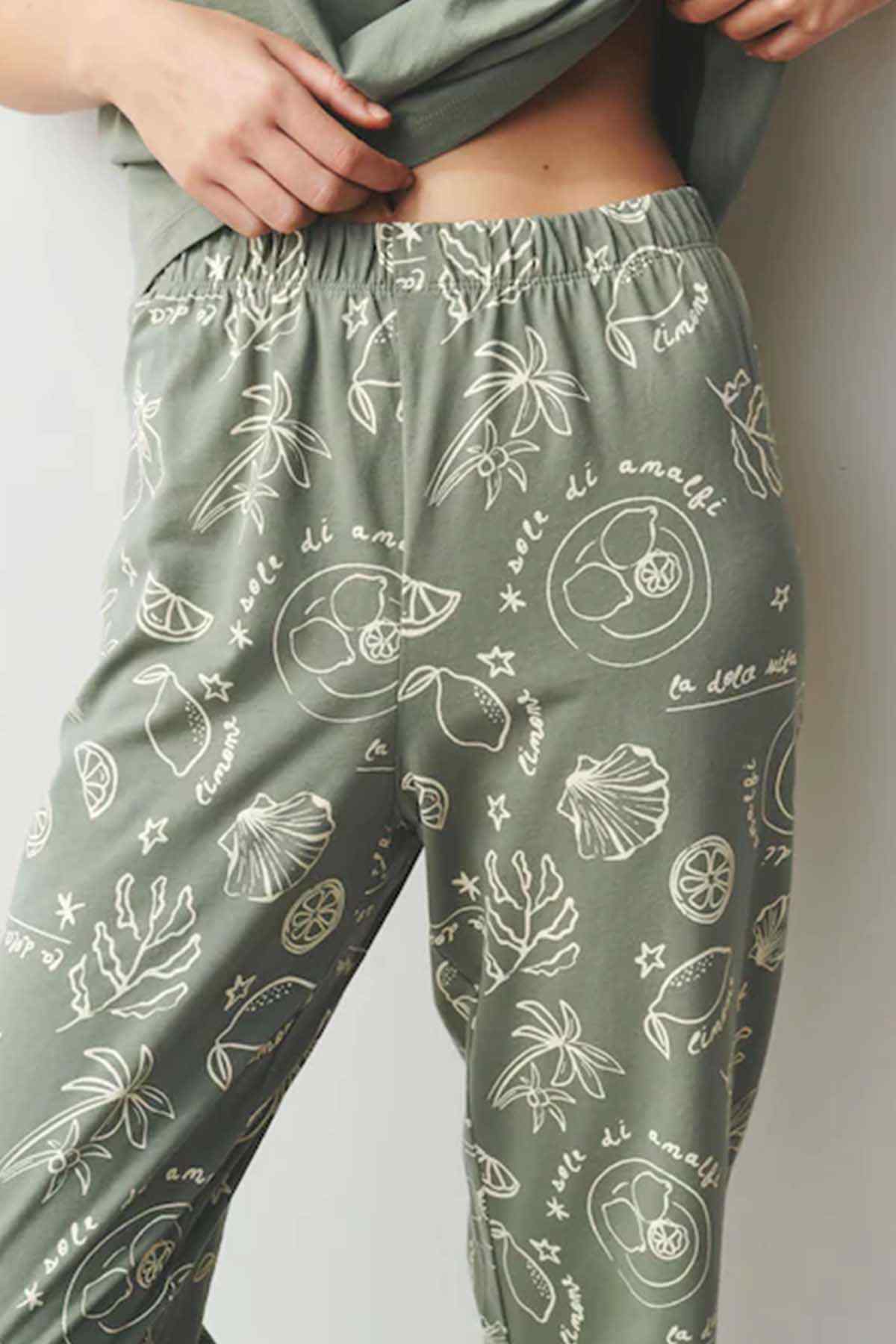 Sage green pajama trousers with elastic waistband and white fruit-and-leaf print