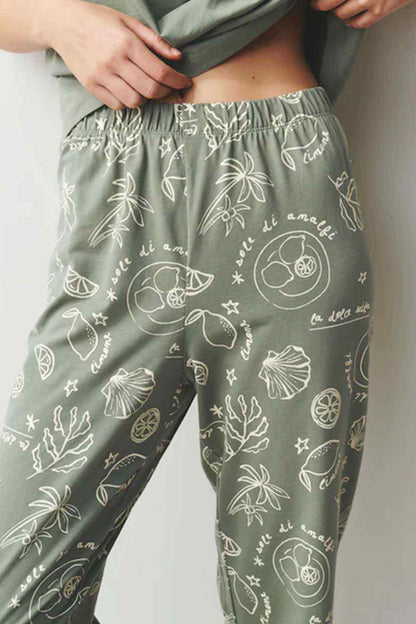 Sage green pajama trousers with elastic waistband and white fruit-and-leaf print