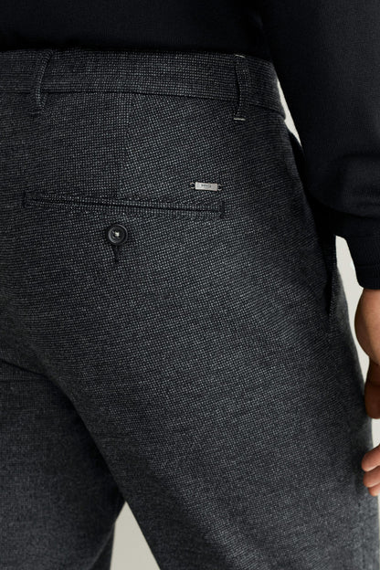 Dark gray melange trousers with front button and waistband belt loops.