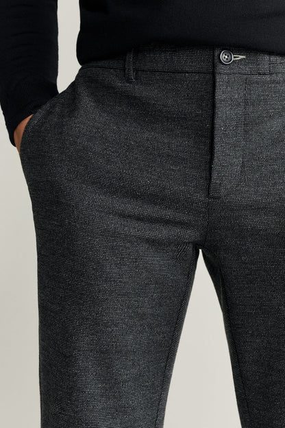 Dark gray textured trouser front with zipper fly and button at waistband.