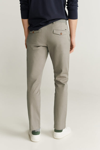 Light grey trousers, straight slim leg, zip fly, side pockets, and cuffed hem.
