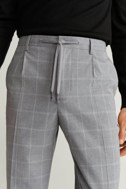 Light heather grey plaid trousers close-up: drawstring tie and front seams