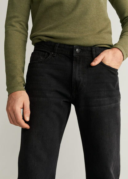 Black denim jeans close-up: belt loops, button waistband, front pockets