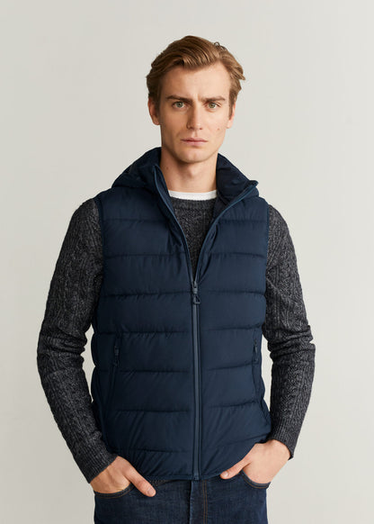 Dark navy quilted hooded puffer vest, zip front, worn over knit sleeves