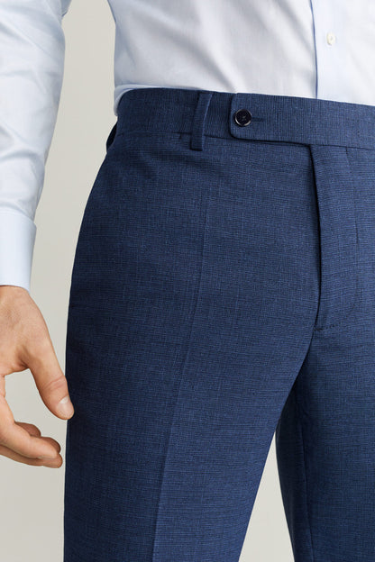 Dark blue suit trousers close-up, waistband with black button and pleat