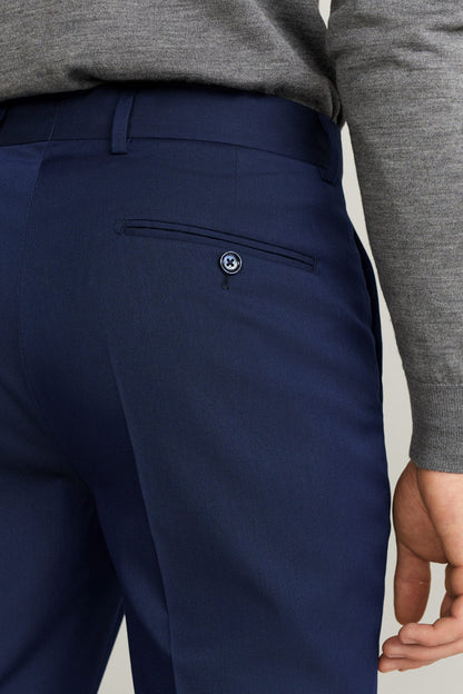 Dark blue suit trousers with belt loops and buttoned welt pocket