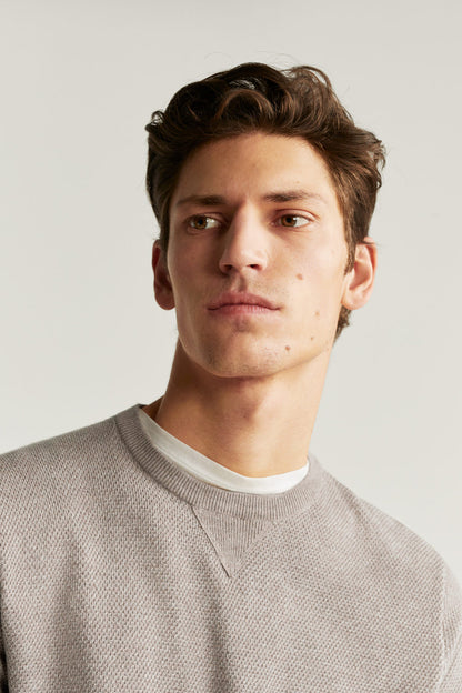Men's knit sweater neckline detail, light gray crew neck with rib trim