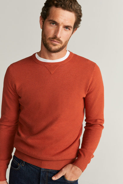 Men's rust-orange crewneck sweater with textured knit and ribbed collar