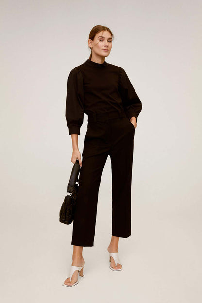 Black high-neck jumpsuit with long puff sleeves and cropped wide-leg pants