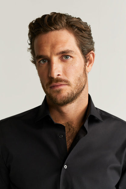 Black dress shirt collar with buttons, long sleeves (close-up).