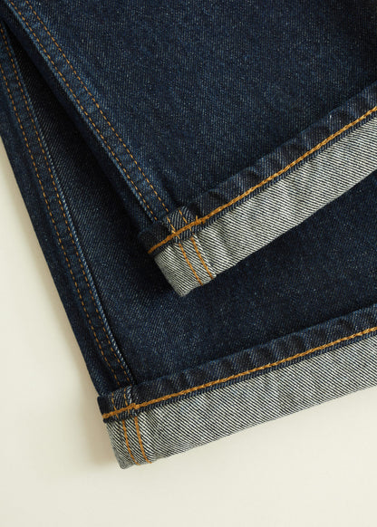 Dark blue denim jeans hem with contrast stitching and light inner facing