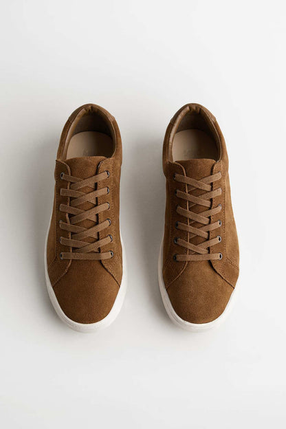 Brown suede lace-up sneakers, top view of tongue and eyelets