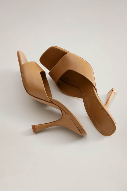 Brown heeled mules with open toe, wide strap, and sculpted block heel