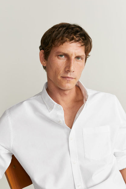 Men's white button-up shirt close-up with chest pocket and pointed collar