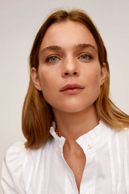 Off-white blouse collar with buttoned V opening and soft ruffled trim